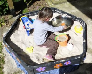 Ein Kind spielt im Sandkasten