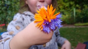 Ein Kind hat Blumen in der Hand